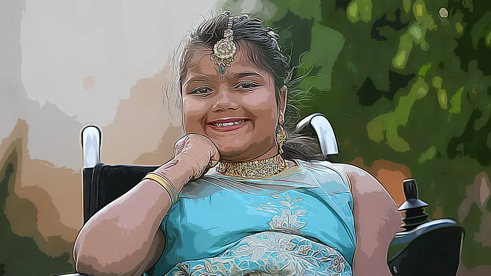 A smiling young girl in a power wheelchair